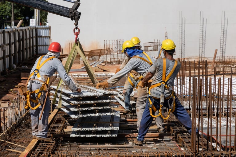 Construction workers placing steel and concrete slab pieces